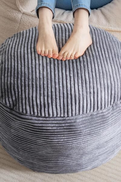 Round stuffed pouf ottoman, corduroy fabric, foam chunk filling, furry foot stool for living room.